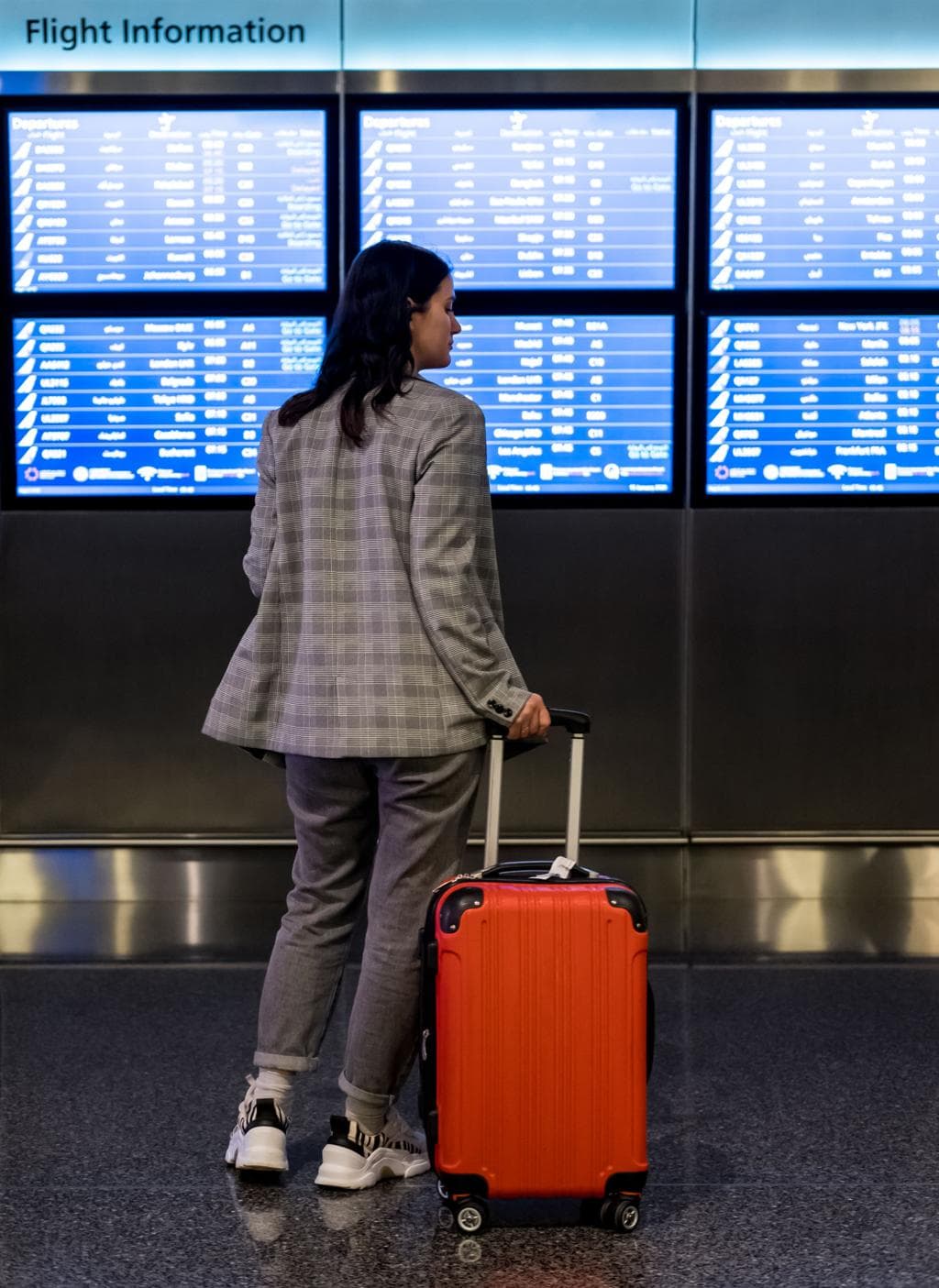 Traveler checking gate information on the flight information board