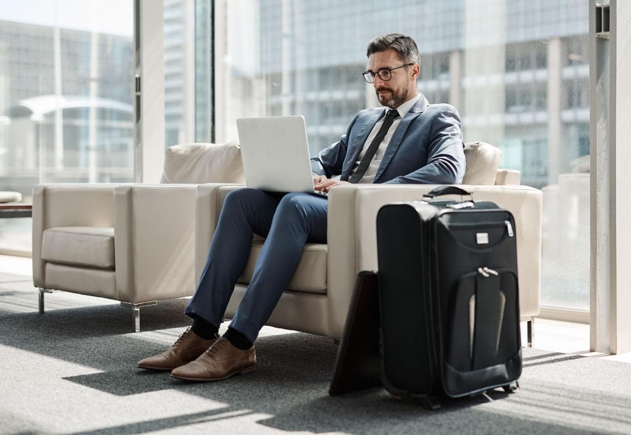 Business traveler working on a laptop in an airport lounge